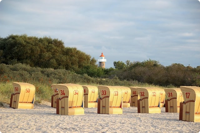 Der Timmendorfer Strand im Sommer mit Strandkörben und Leuchtturm.